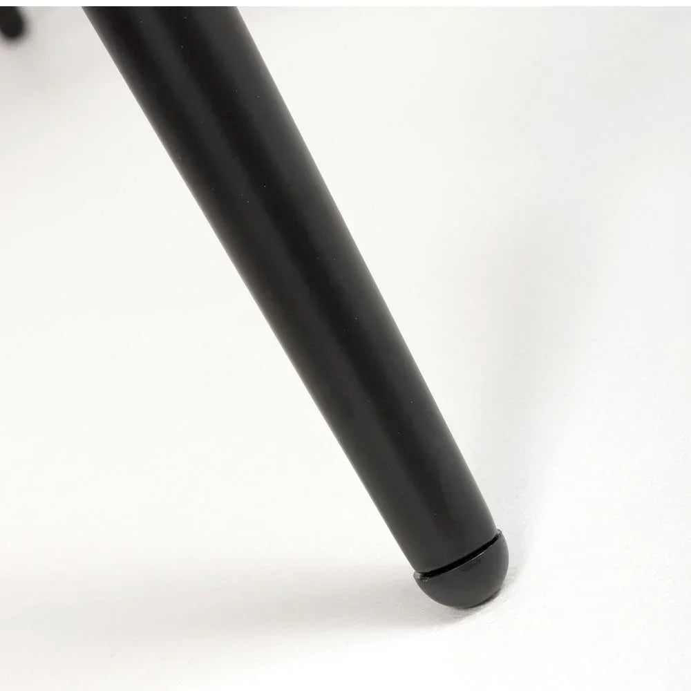 Close-up of black metal chair leg with rounded foot on white floor