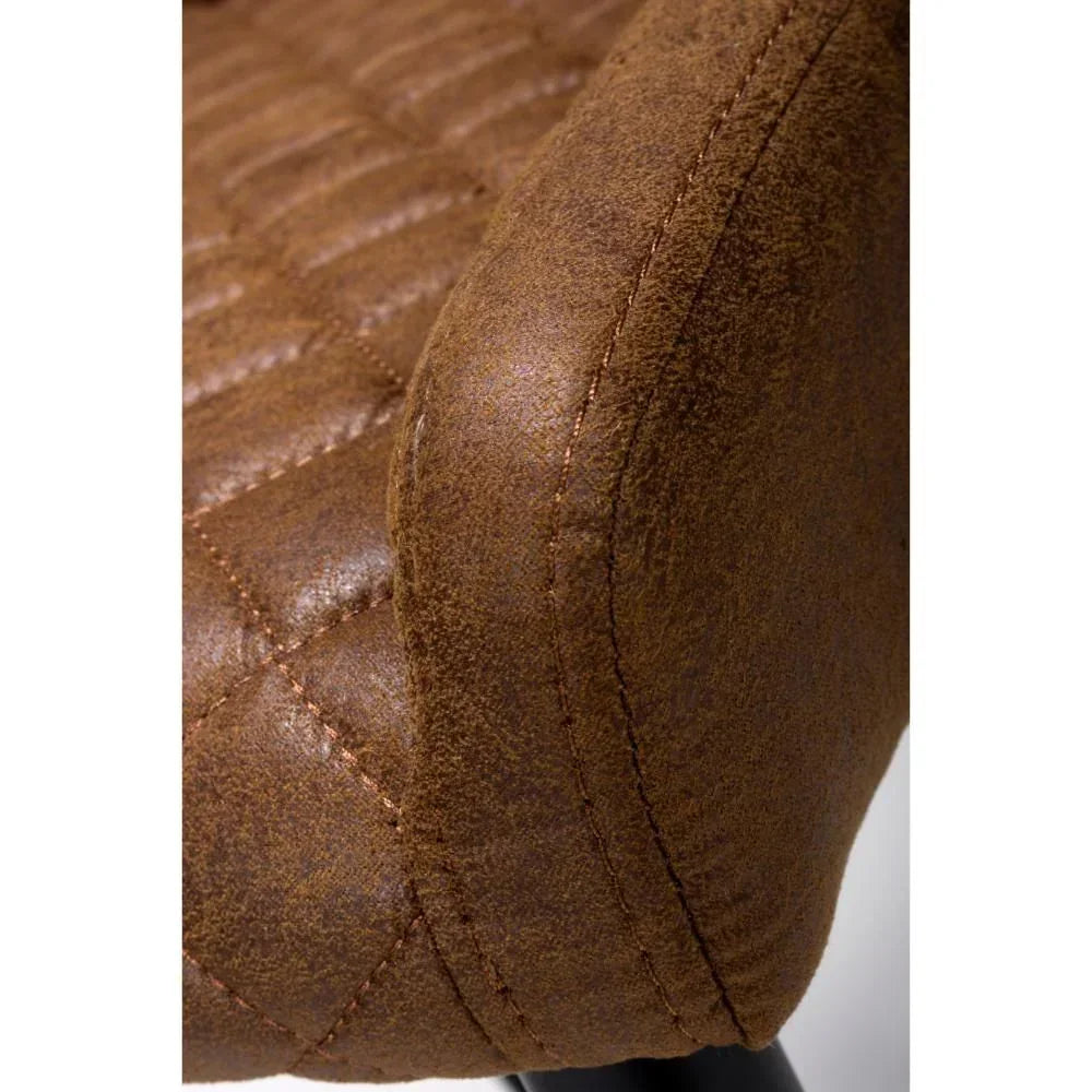 Close-up of brown faux leather chair seat with quilted stitching and curved arm detail