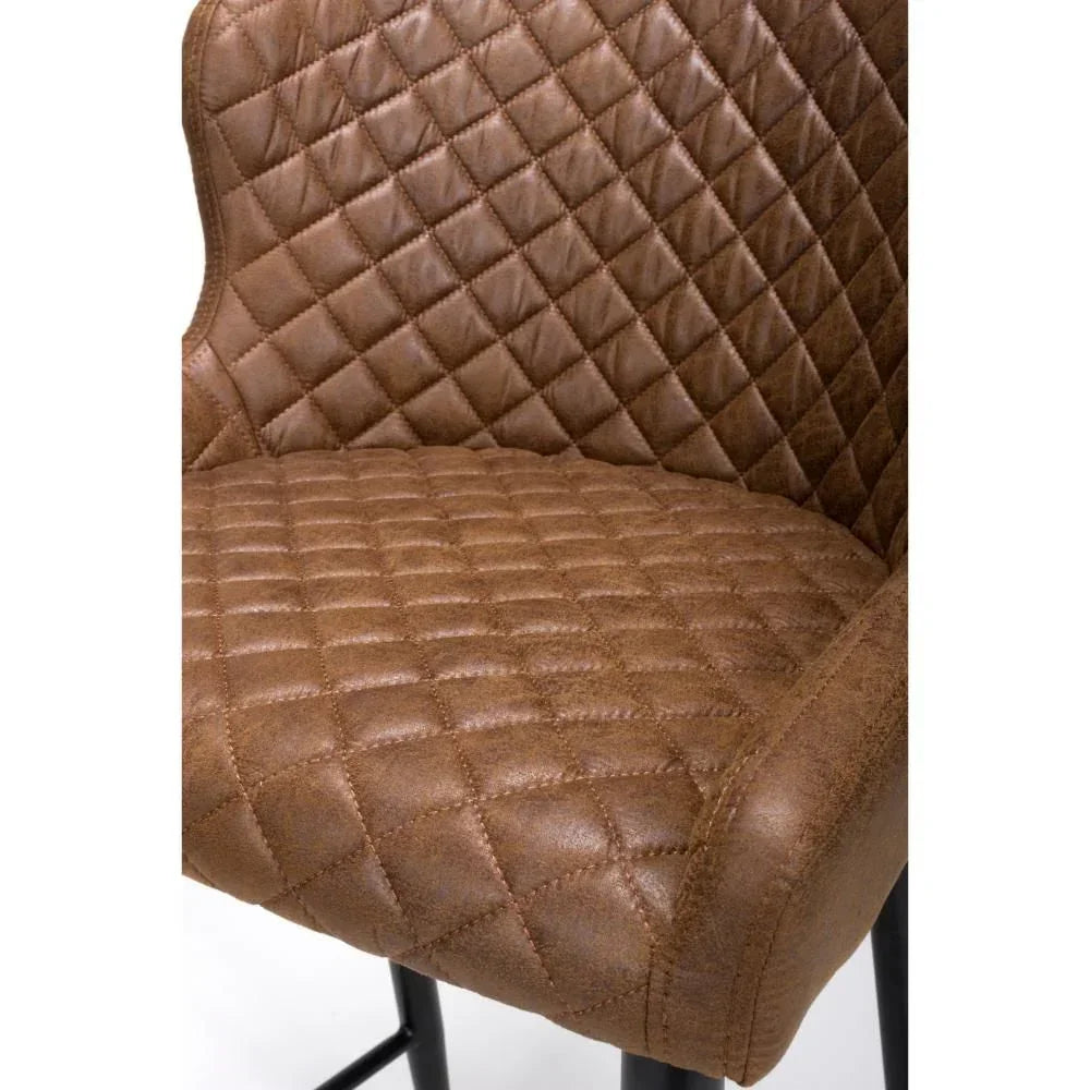 Quilted brown faux leather bar stool seat with black metal legs close-up