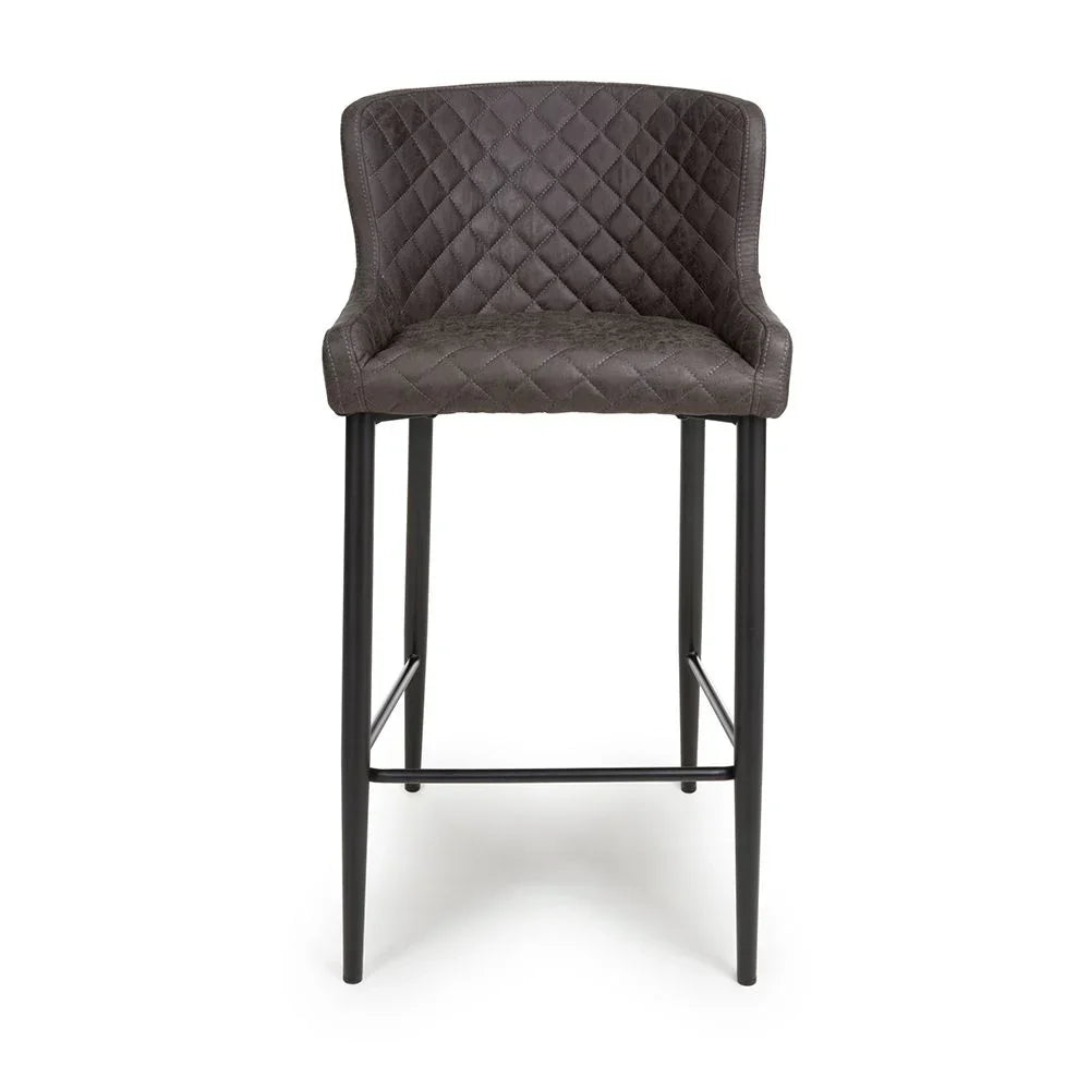 Dark grey quilted bar stool with black metal legs and low backrest, front view