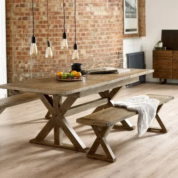 Rustic wooden dining table with matching bench and fruit bowl in loft-style dining room