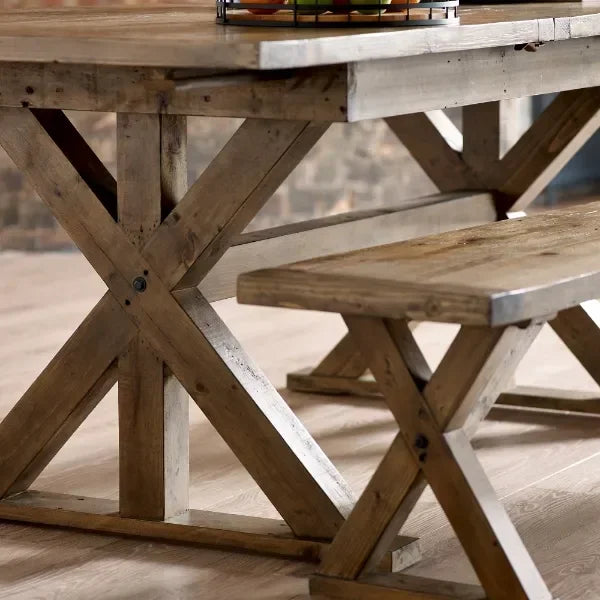 Rustic wooden dining table and bench set with cross-leg design on wooden floor