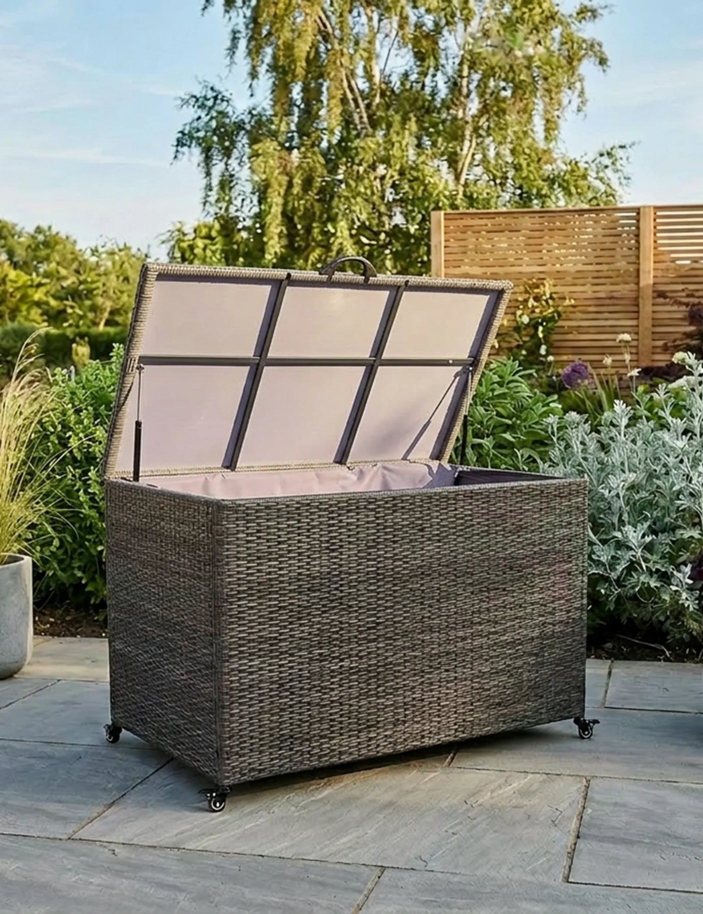 Brown rattan outdoor storage box with open lid on patio