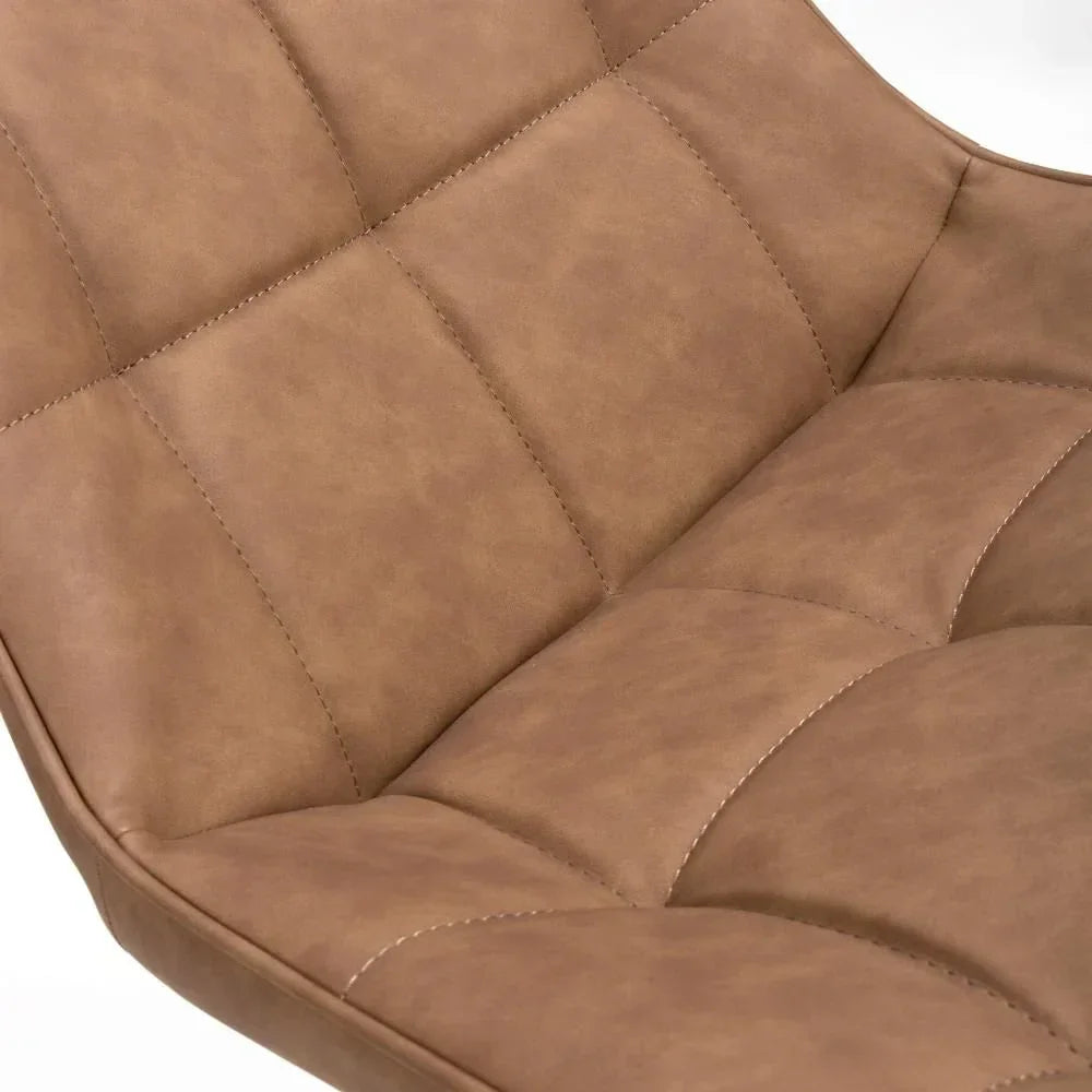 Close detail of tan faux leather dining chair seat with stitched padded panels