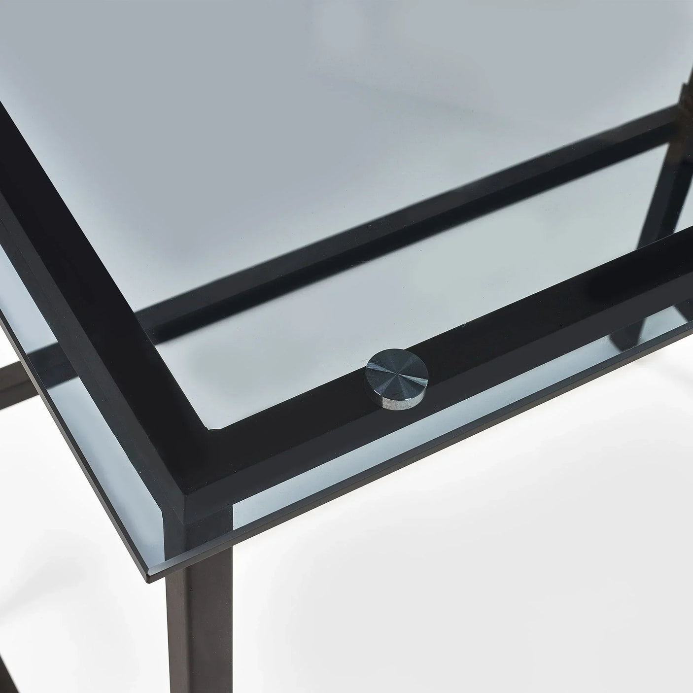Glass desk corner with black metal frame and round support detail