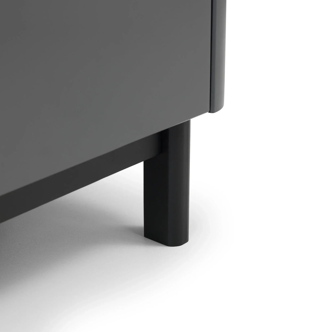 Close-up of grey cabinet leg with matte black metal finish on white floor