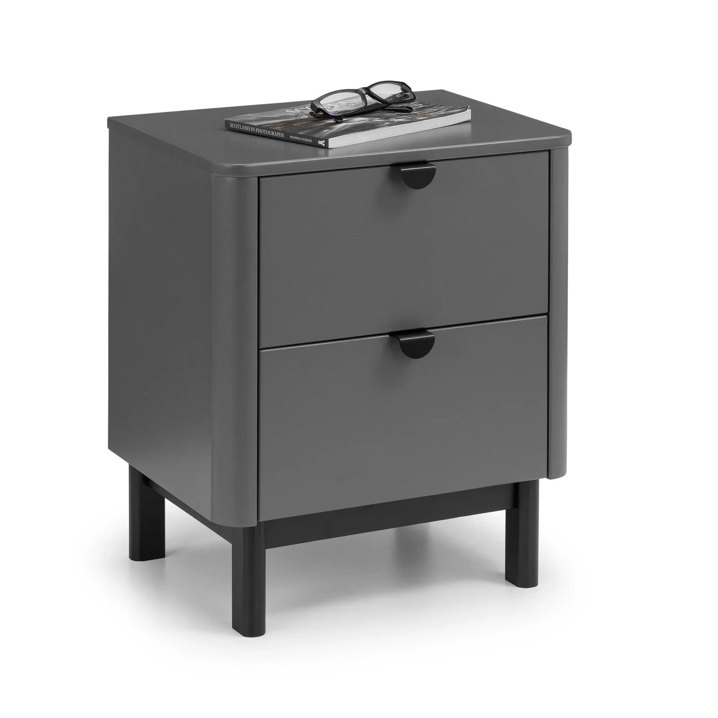 Grey bedside cabinet with two drawers and black legs, book and glasses on top