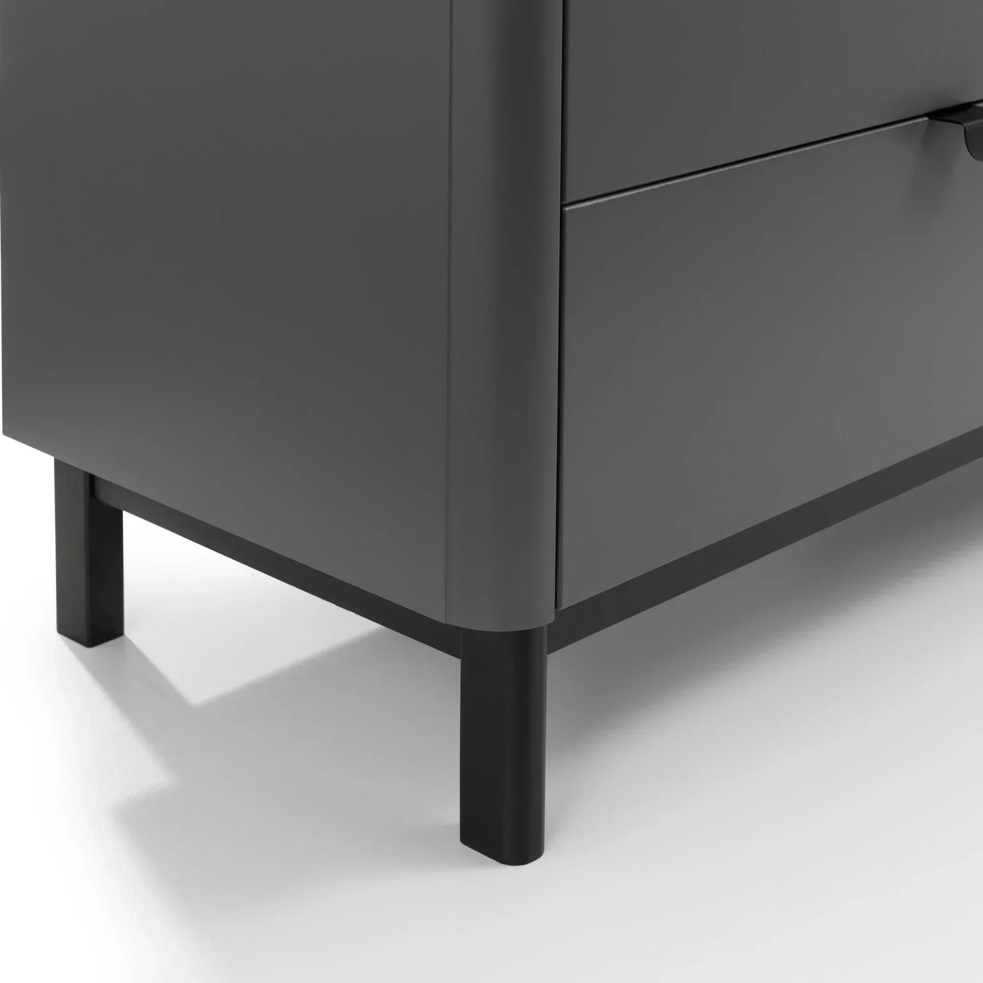 Close-up of grey cabinet corner with metal legs and two visible drawer fronts