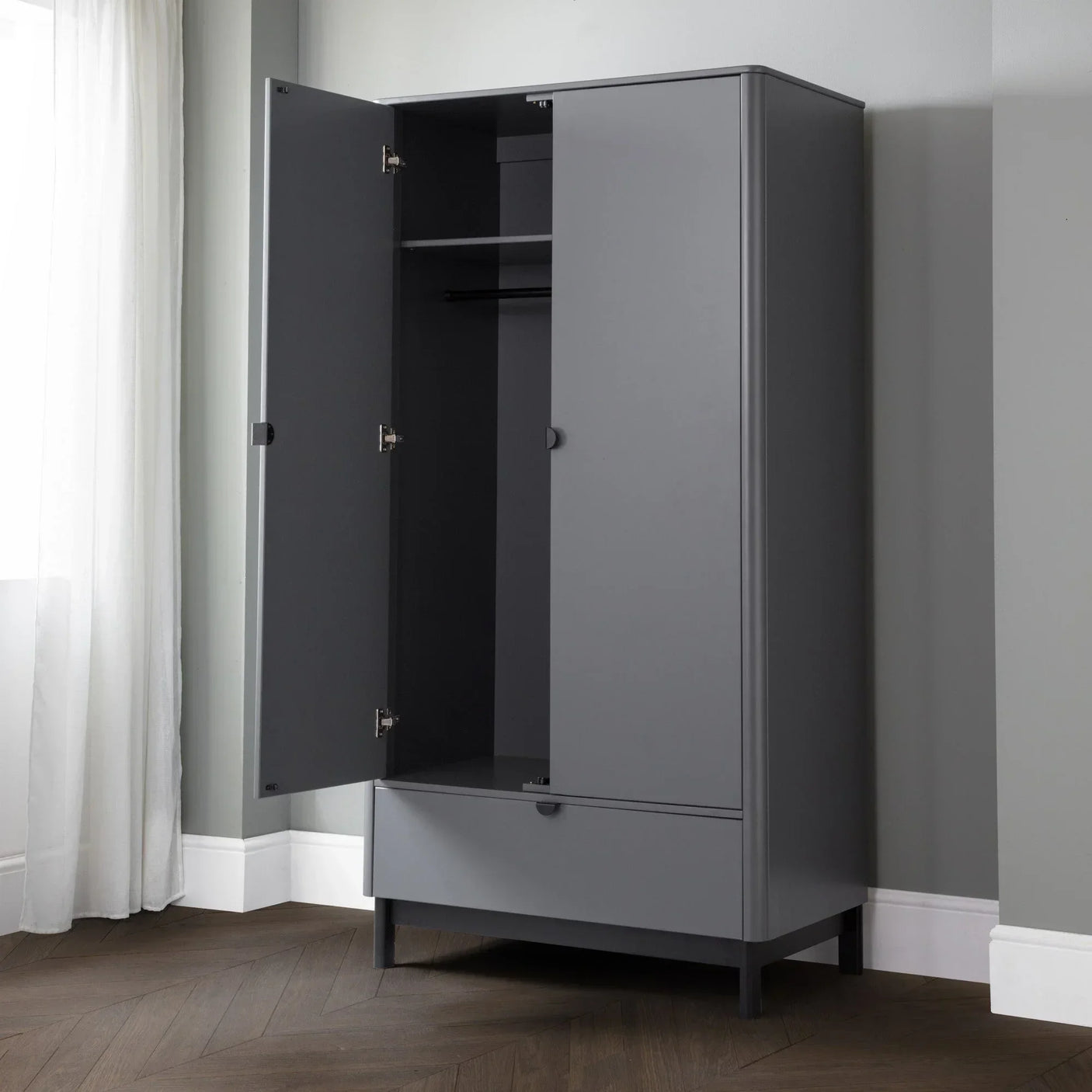 Grey wardrobe with open doors, shelf, hanging rail, and lower drawer in modern bedroom