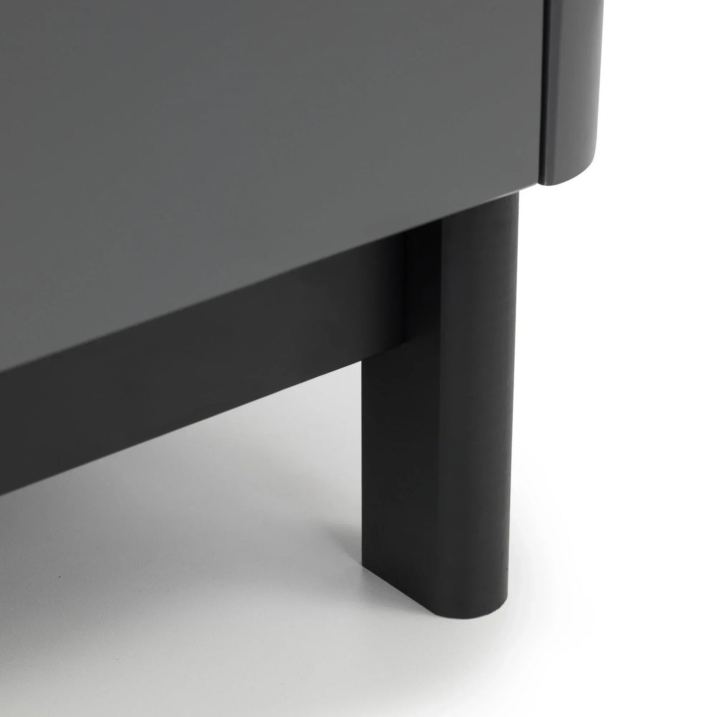 Close-up of grey furniture leg and corner panel on light background