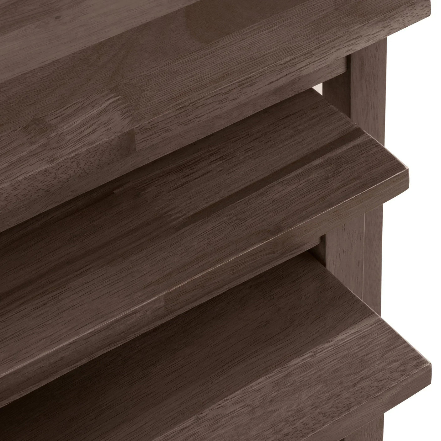 Close-up of dark wood chest of drawers corner with slatted detail