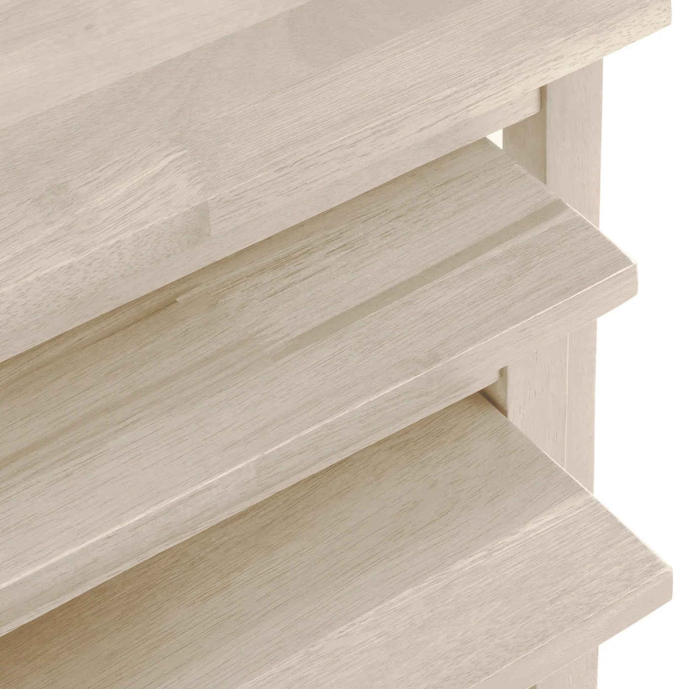 Close-up of light wood chest of drawers with slatted drawer fronts