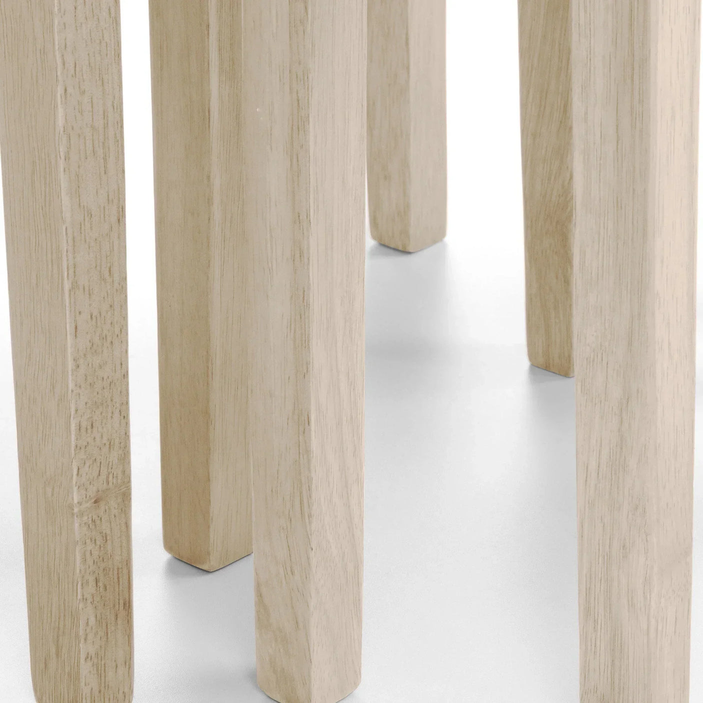 Close-up of solid wood dining table legs in natural finish on white background