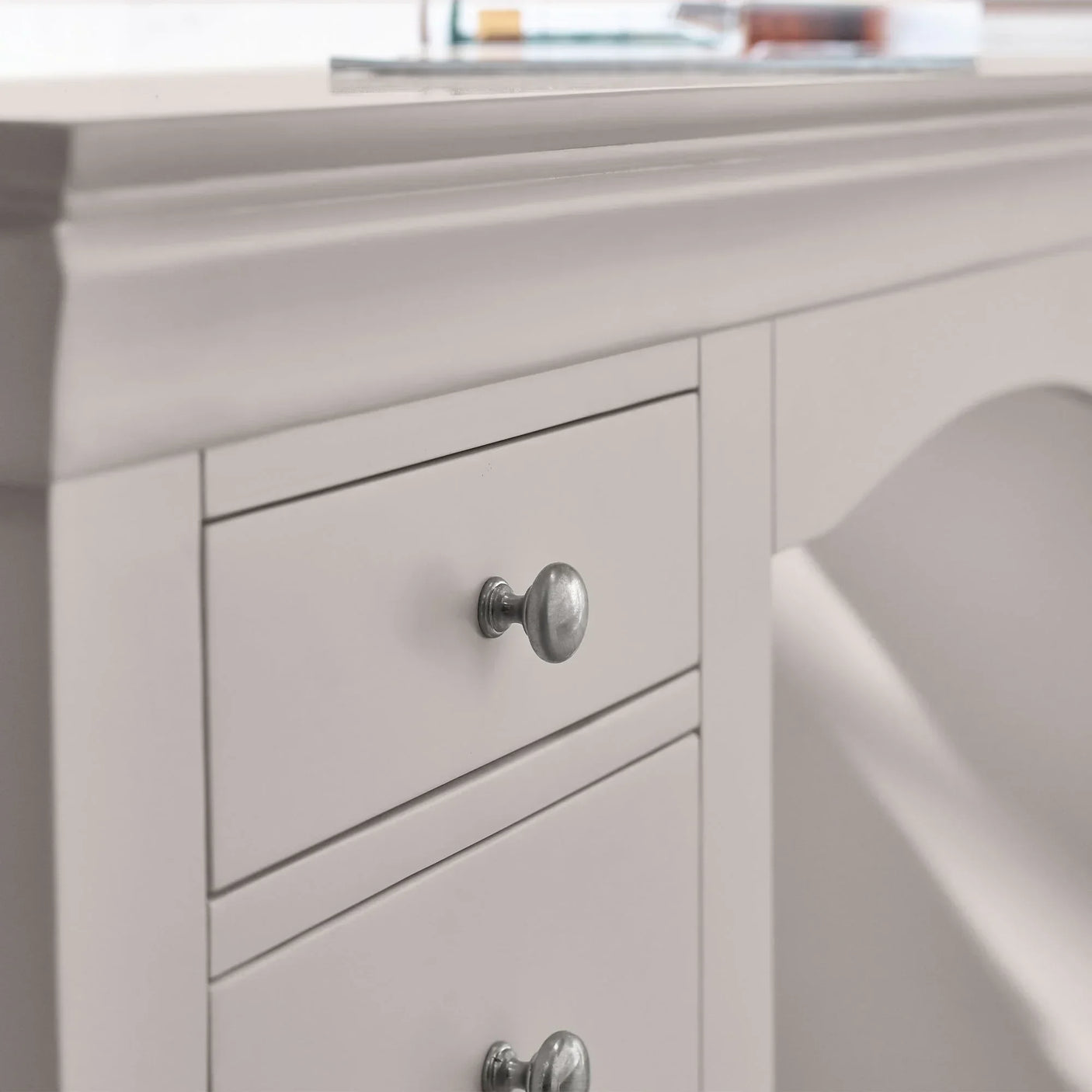 Grey dressing table with silver knobs and detailed drawer front