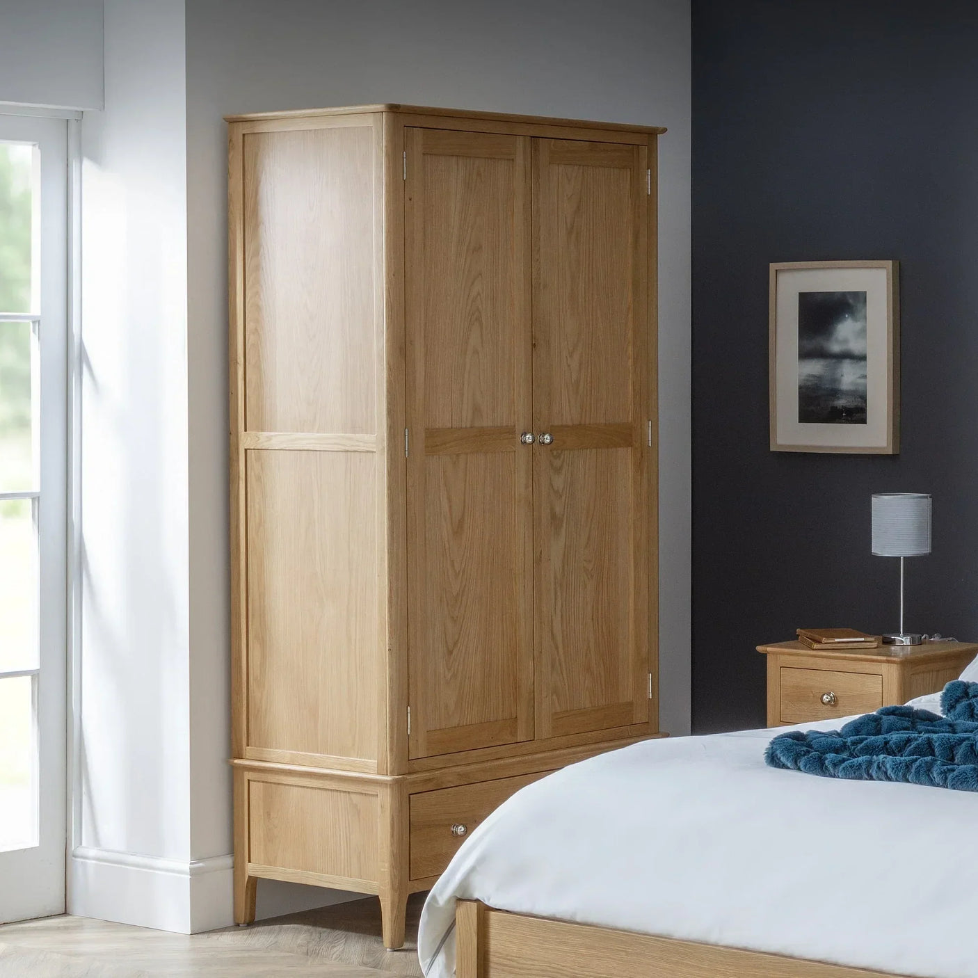 Oak 2 door 1 drawer wardrobe in modern bedroom next to window and bedside table