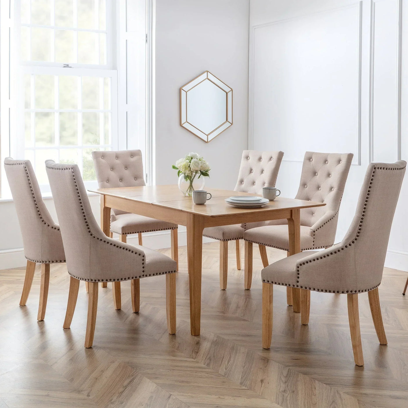 Cotswold extending dining table with six beige upholstered chairs in a bright dining room