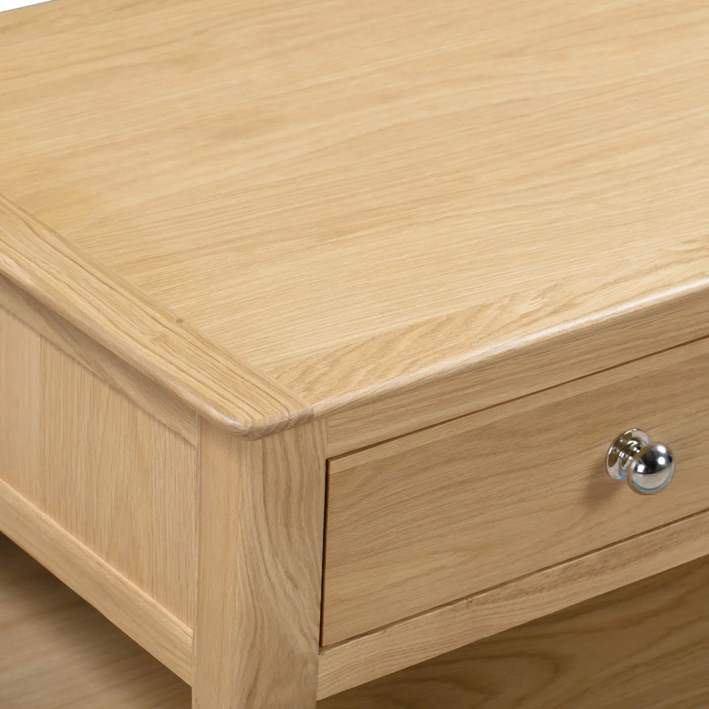 Oak coffee table corner detail showing drawer front with chrome handle