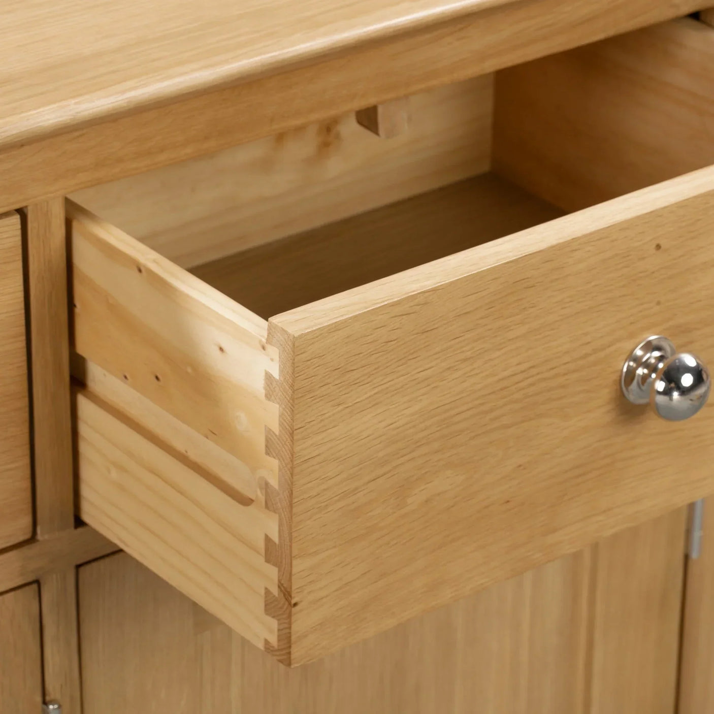 Oak sideboard drawer with dovetail joints and chrome handle, partial open view