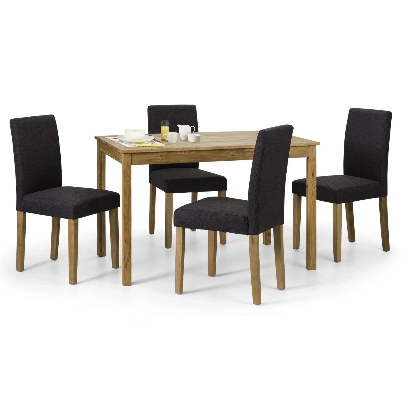 Rectangular oak dining table with four black fabric chairs and breakfast setup