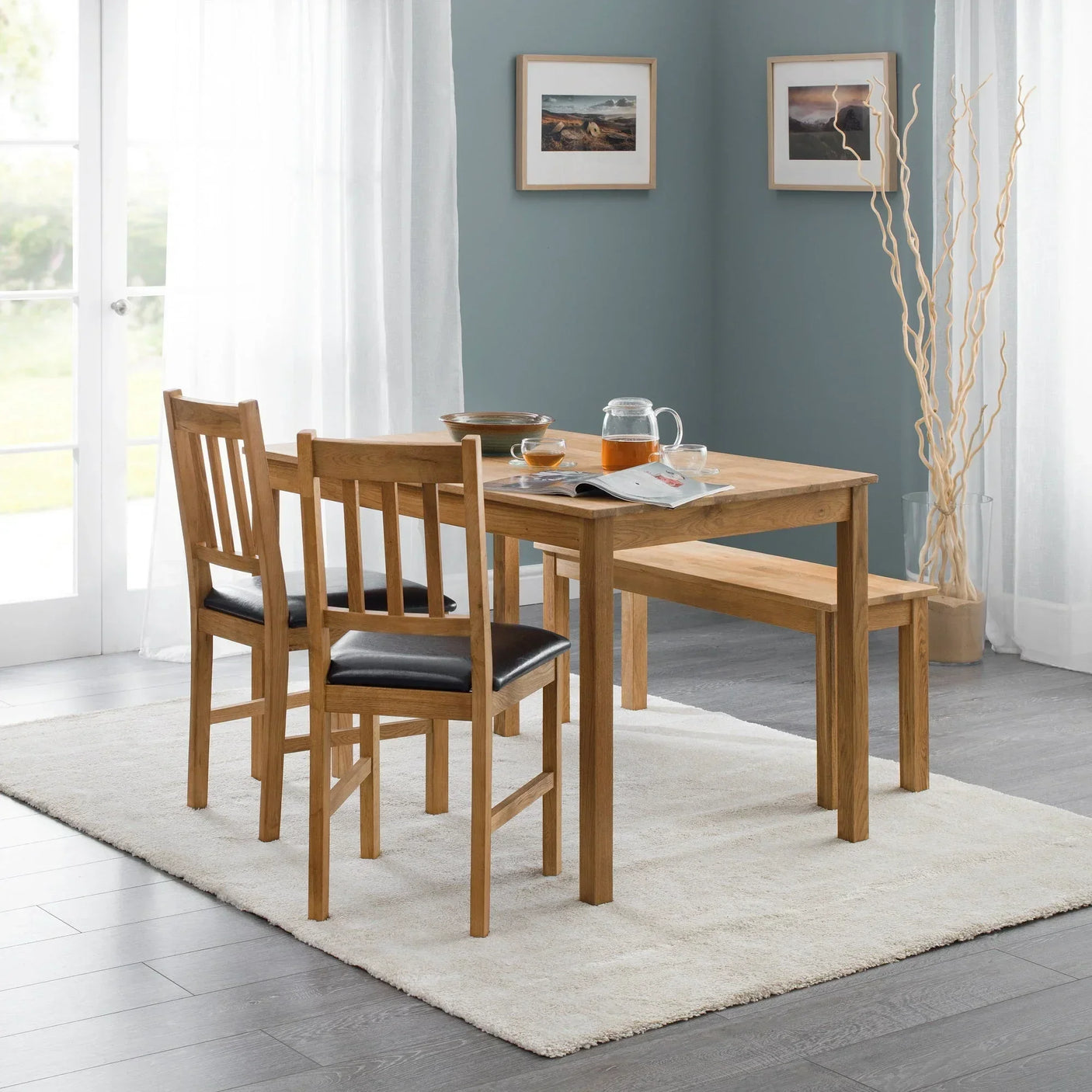 Oak rectangular dining table with two chairs and bench on cream rug in modern dining room