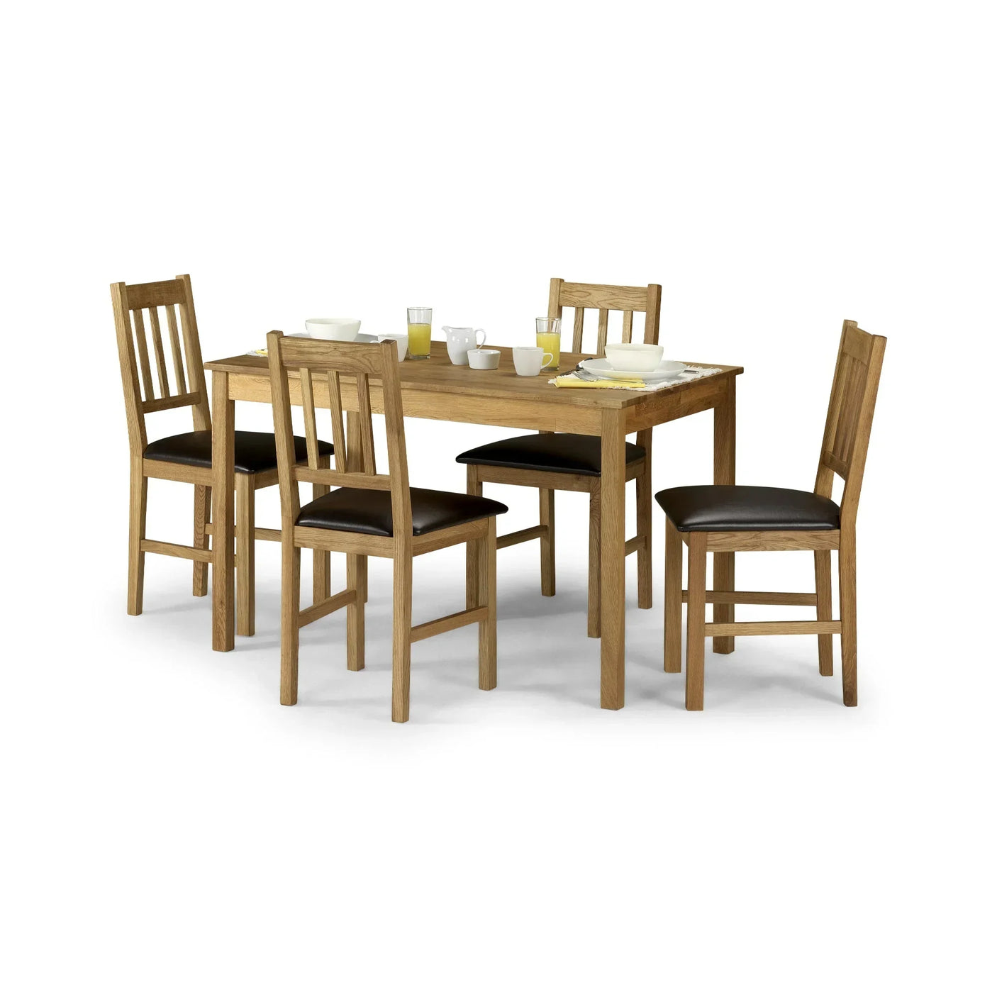 Oak dining table set with four slatted back chairs and black seat pads, tableware on top