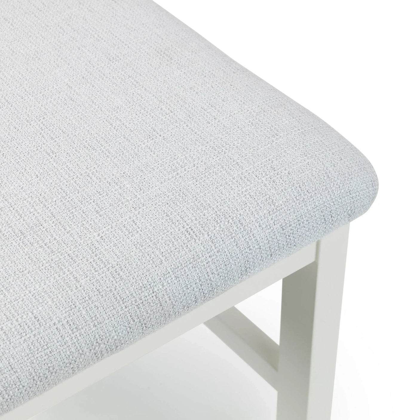Ivory fabric dining chair close-up showing textured upholstery and white wooden frame