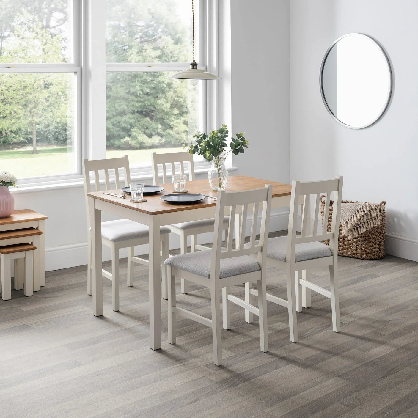 Ivory wooden dining chairs with grey cushions around a rectangular oak dining table in bright room
