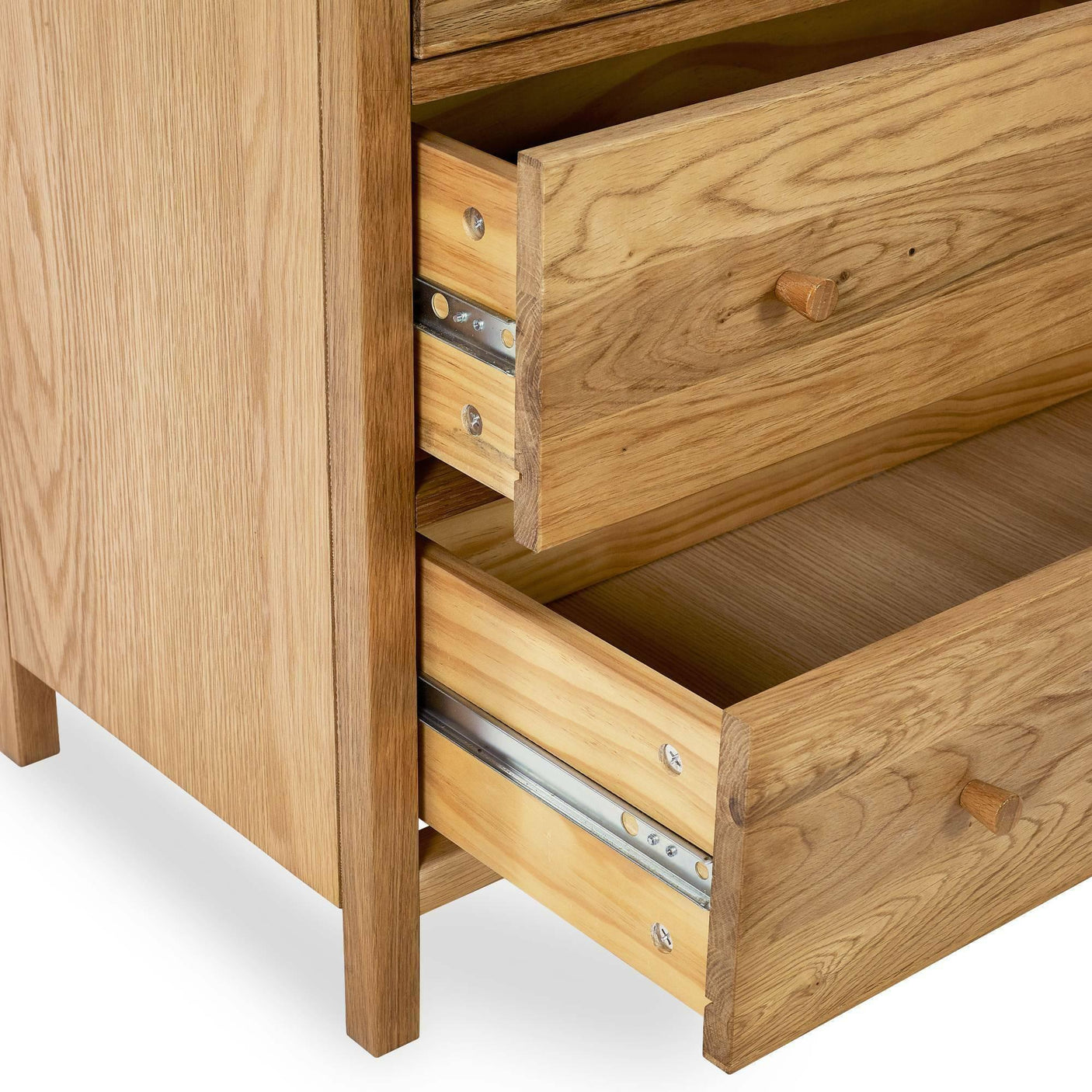 Oak chest of drawers with two drawers open showing wood grain and metal runners