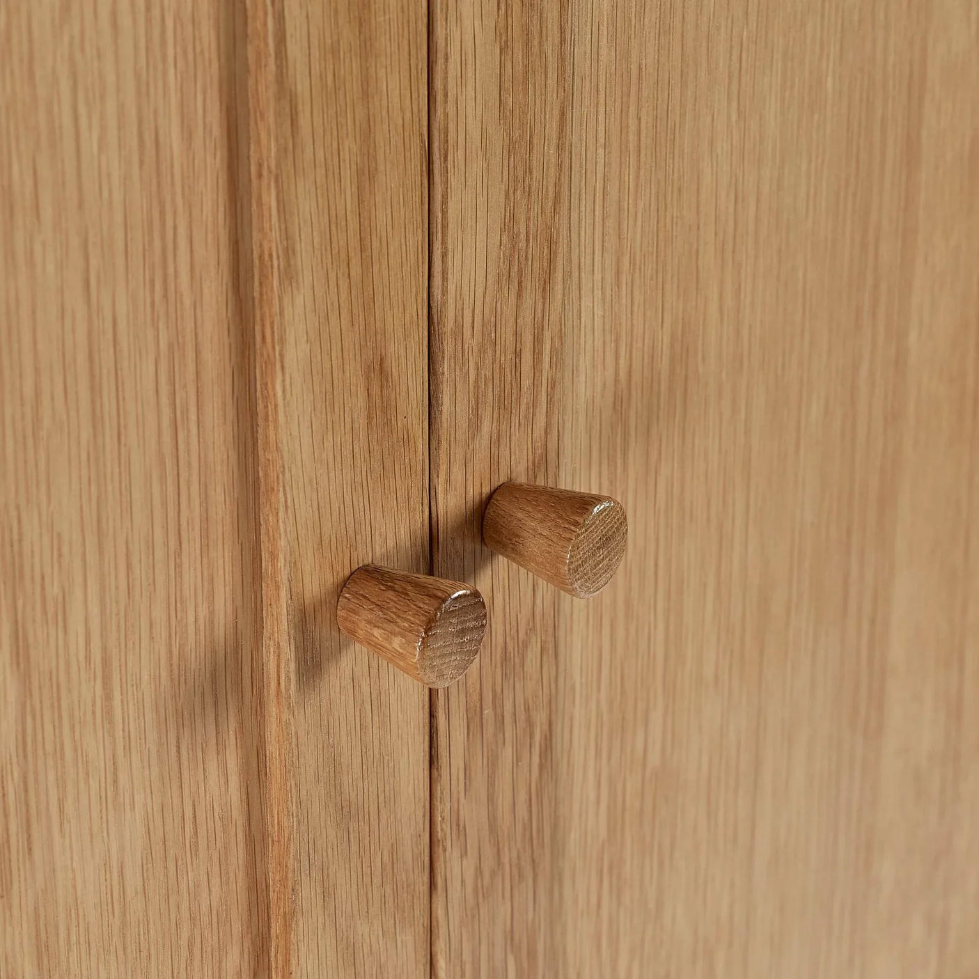 Closeup of oak cabinet doors with round wooden handles