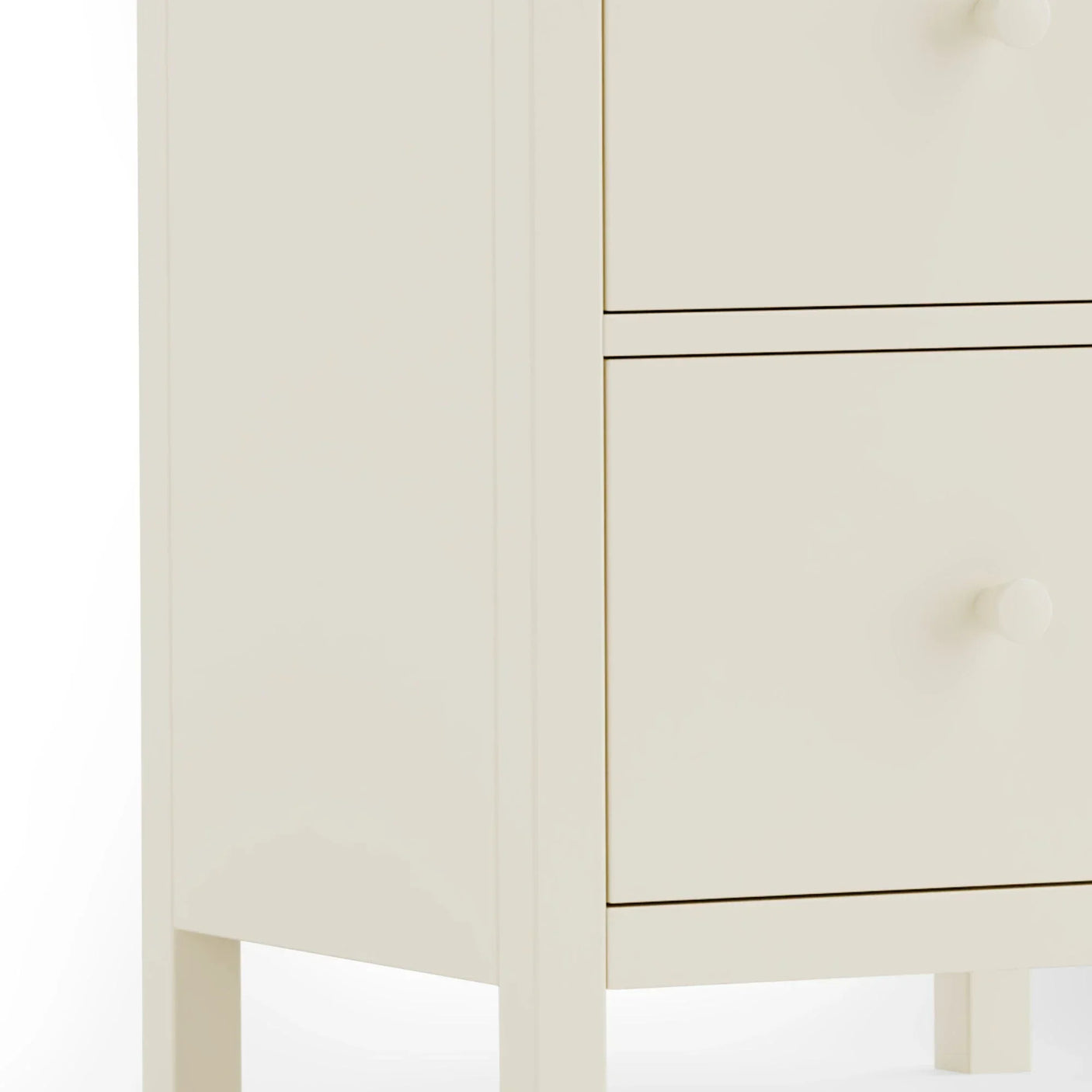 Cream wooden chest of drawers close-up showing drawer fronts and round handles