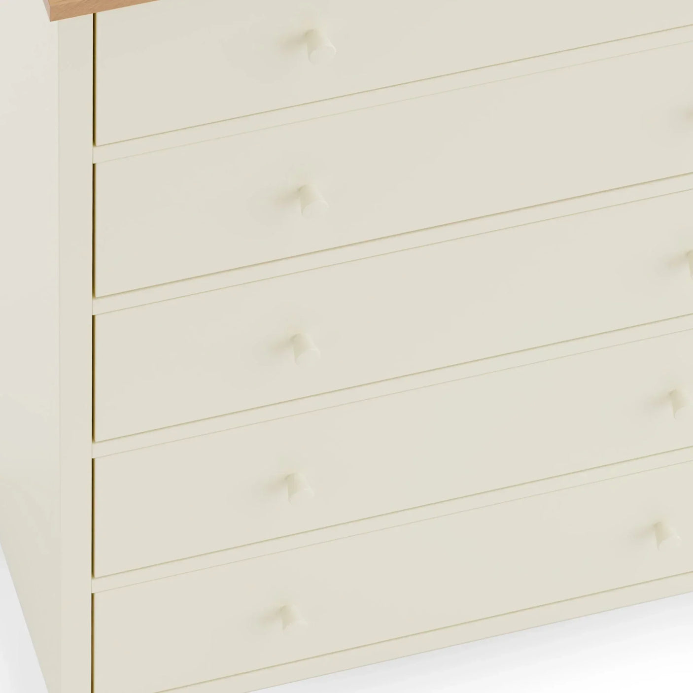 Cream chest of drawers with simple round knobs and wood top, close-up front view
