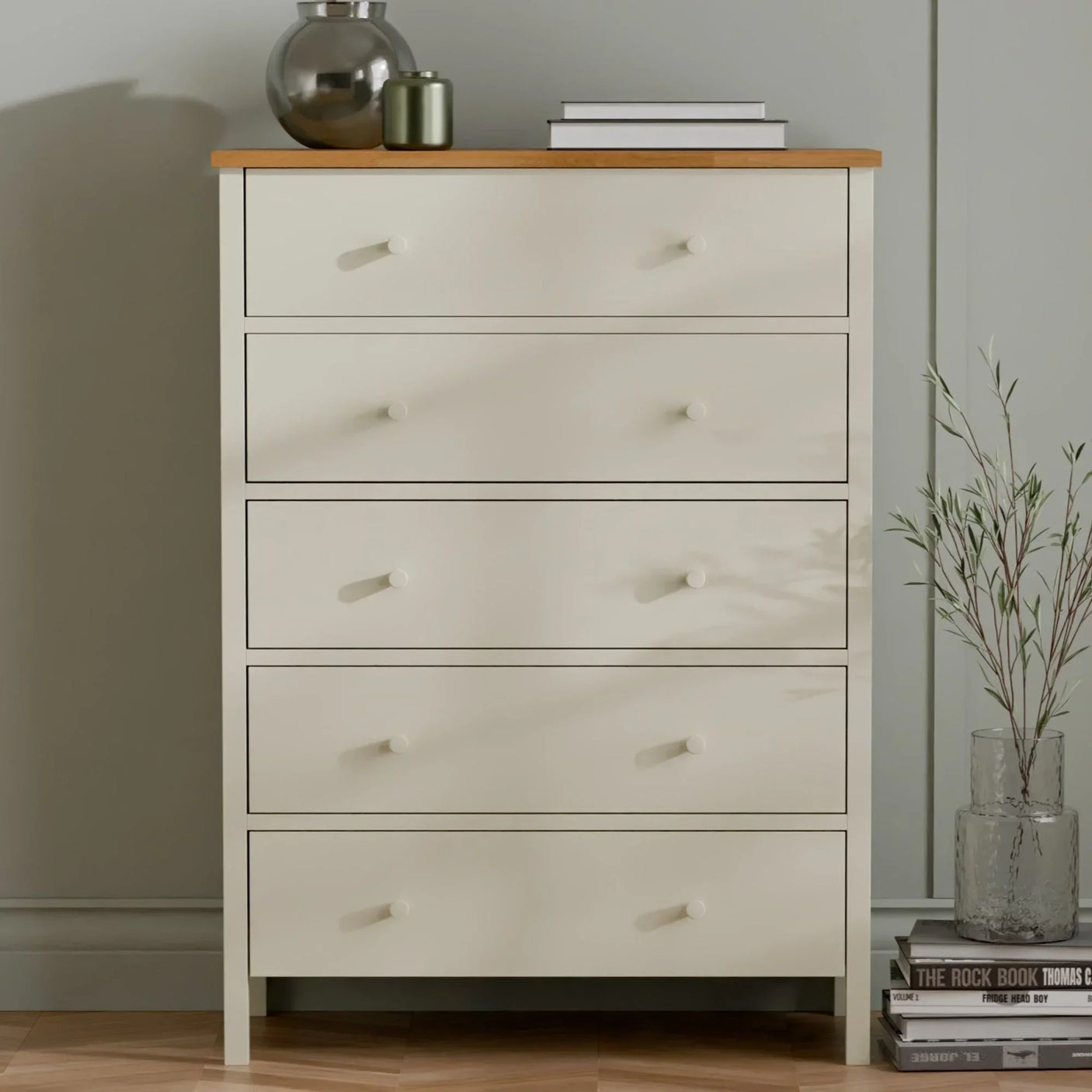 Cream chest of drawers with wooden top, styled with vases, books and plant decor