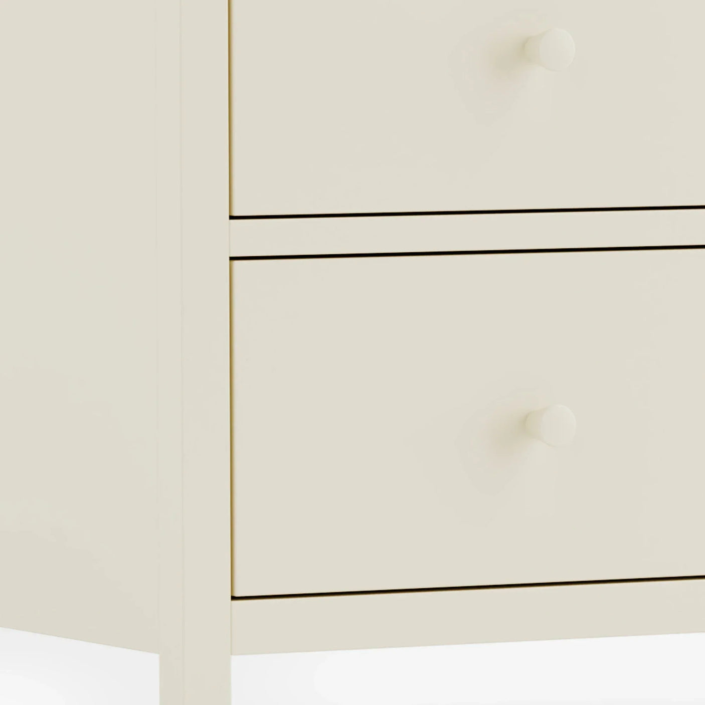Close-up of cream bedside table drawers with round handles