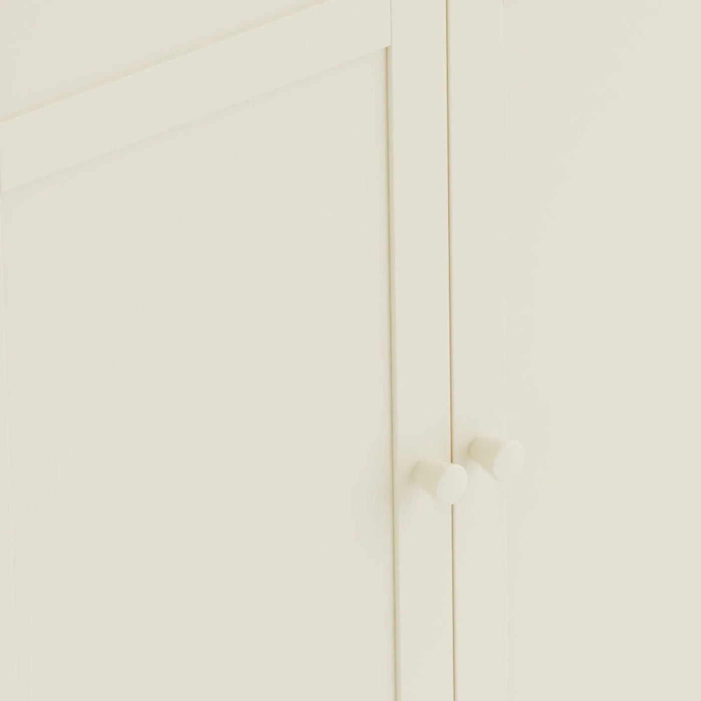 Close-up of cream wooden cabinet doors with round handles