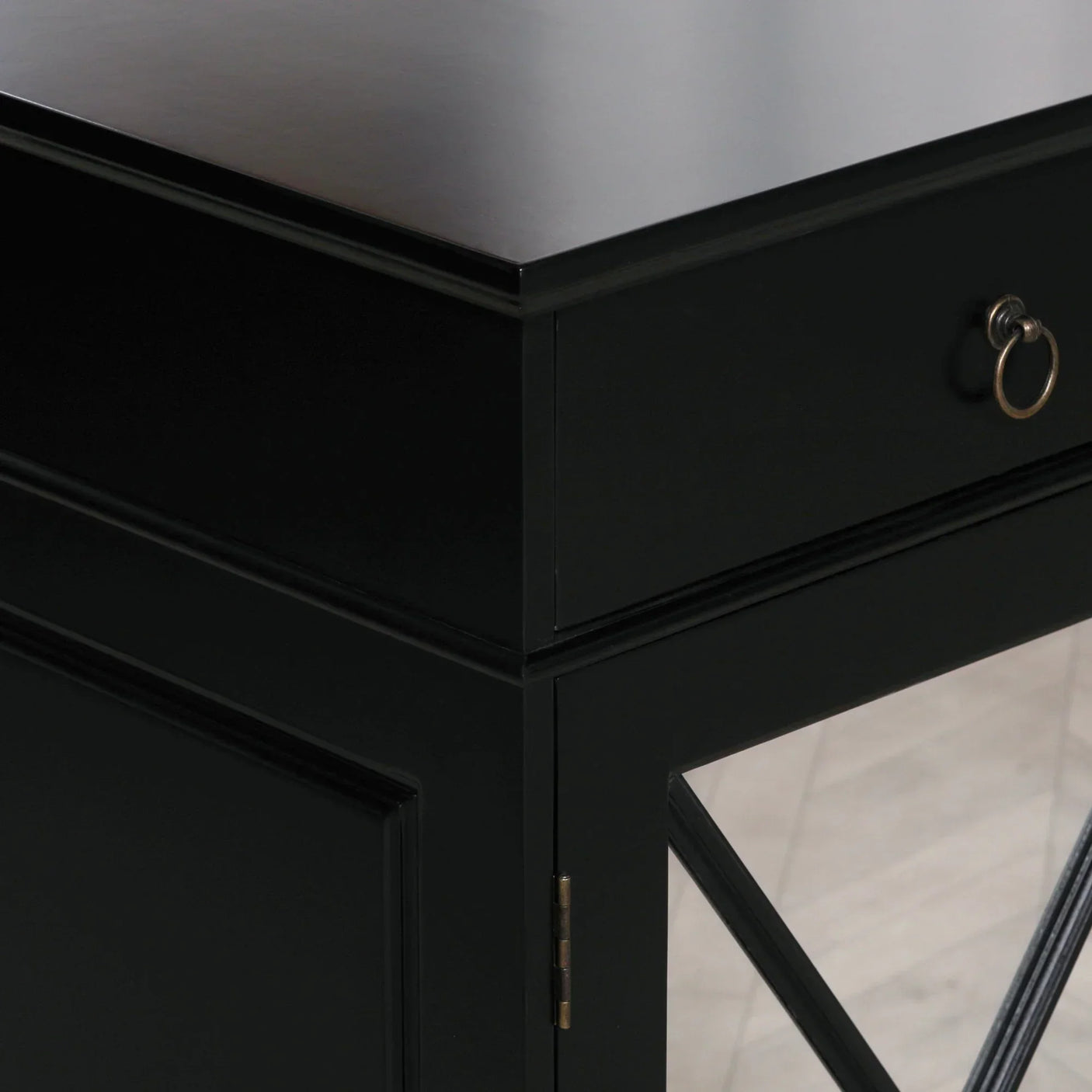 Black sideboard cabinet corner with drawer, metal handle and glass panel detail
