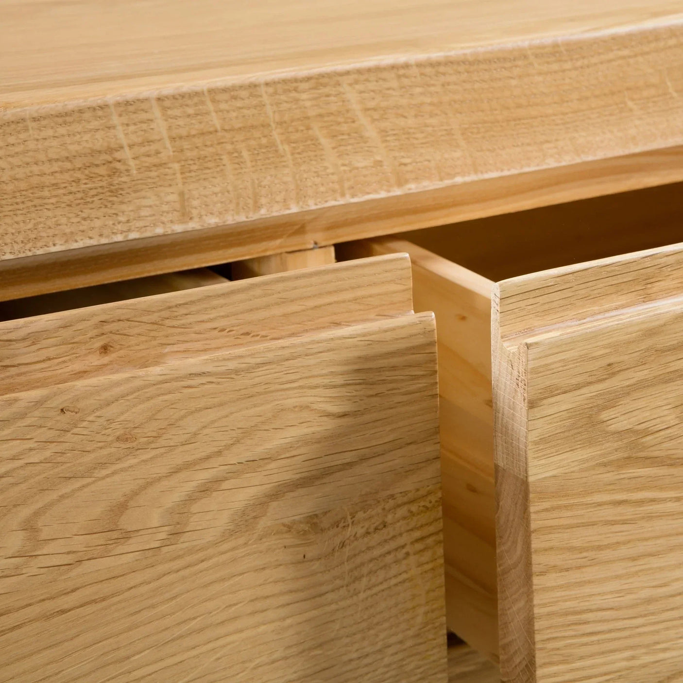 Detail view of oak 3 drawer chest with open drawers showing wood grain texture