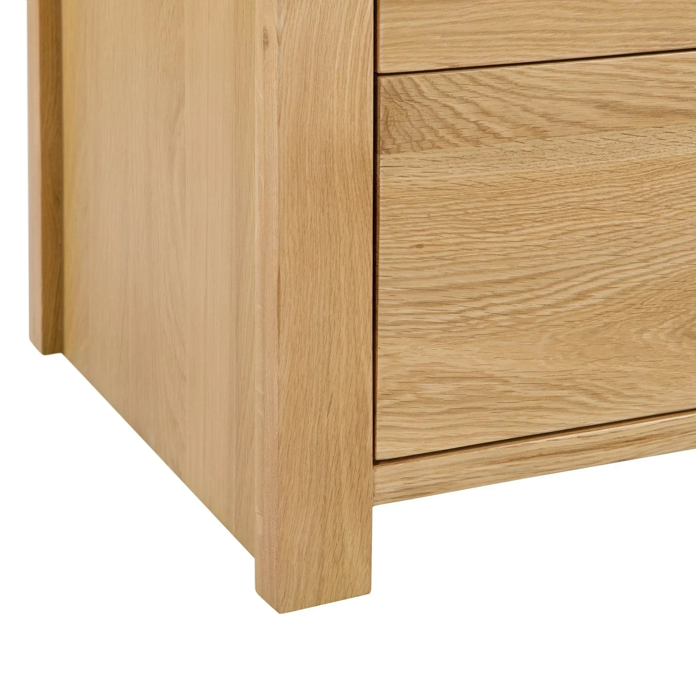 Close-up of oak chest of drawers corner with visible wood grain and clean lines