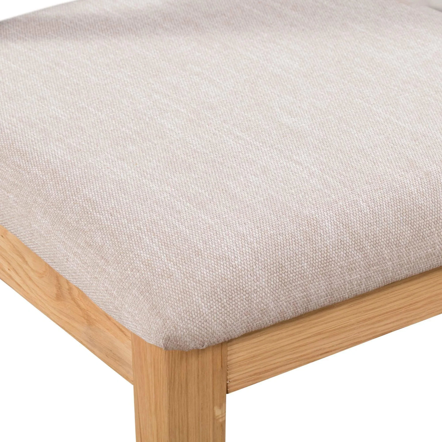 Closeup of Curve oak dining chair corner with beige upholstered seat cushion