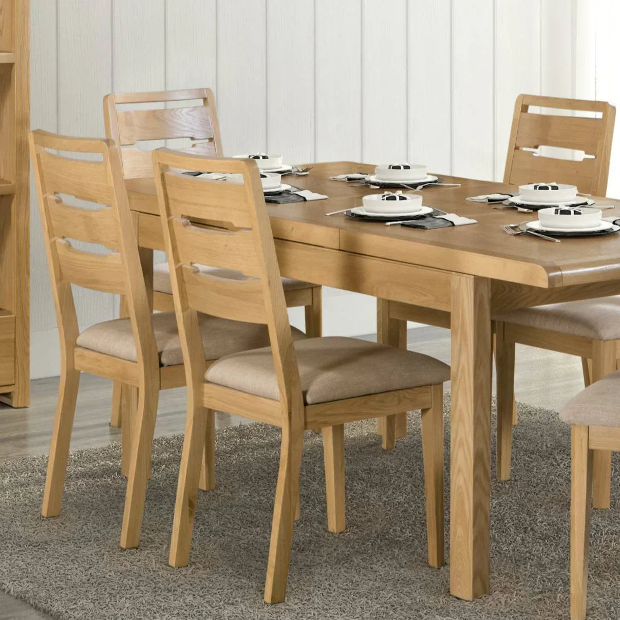 Curve oak dining chair with beige cushion around rectangular oak dining table