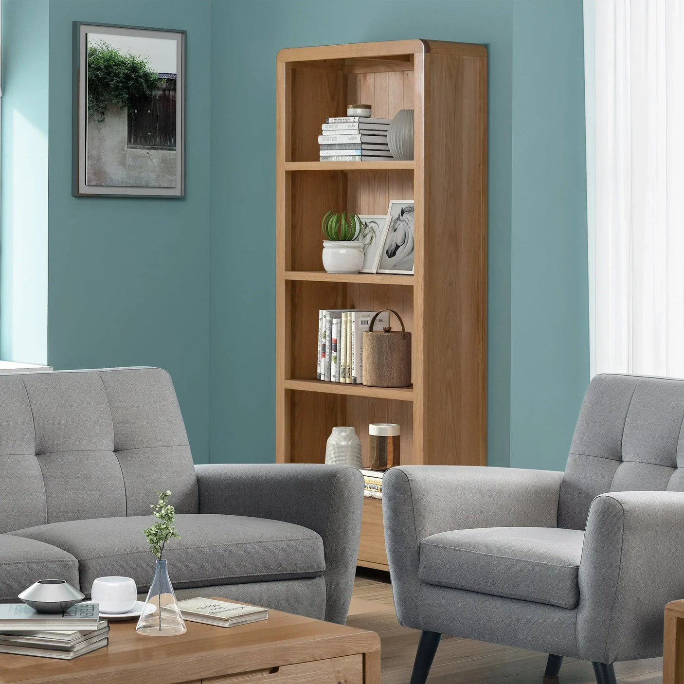 Oak tall bookcase with shelves in living room beside grey armchair and sofa