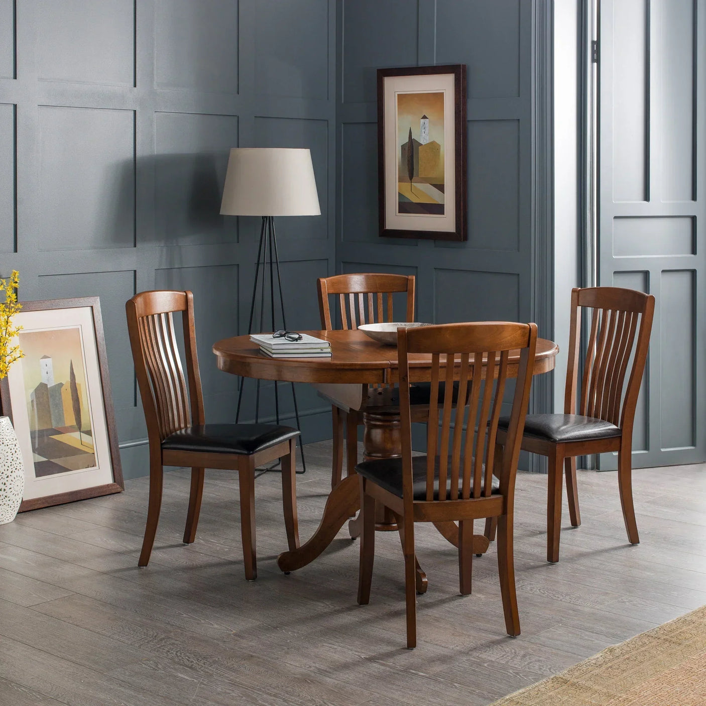 Wooden dining table set with four chairs and black seat pads in a modern dining room