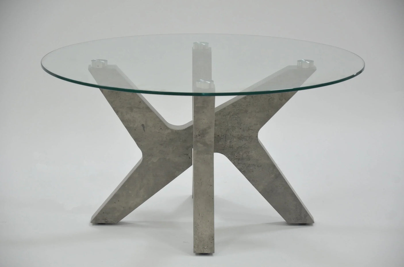 Grey marble coffee table with round glass top and sculpted stone base on white background