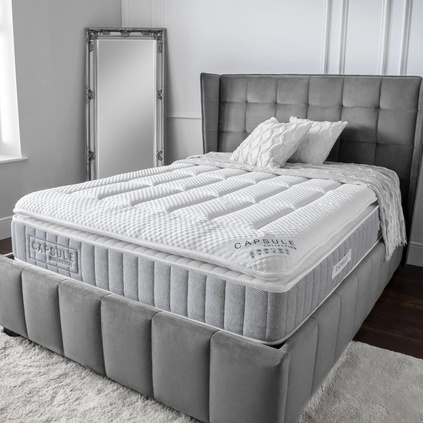 Capsule pillow top mattress on grey upholstered bed frame in modern bedroom