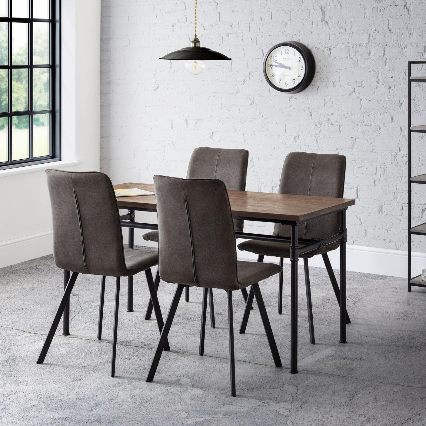 Rectangular wood dining table with four grey upholstered dining chairs in modern room
