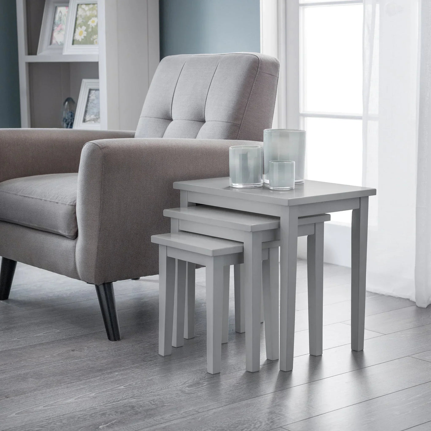 Grey nest of tables with straight legs beside armchair in modern living room