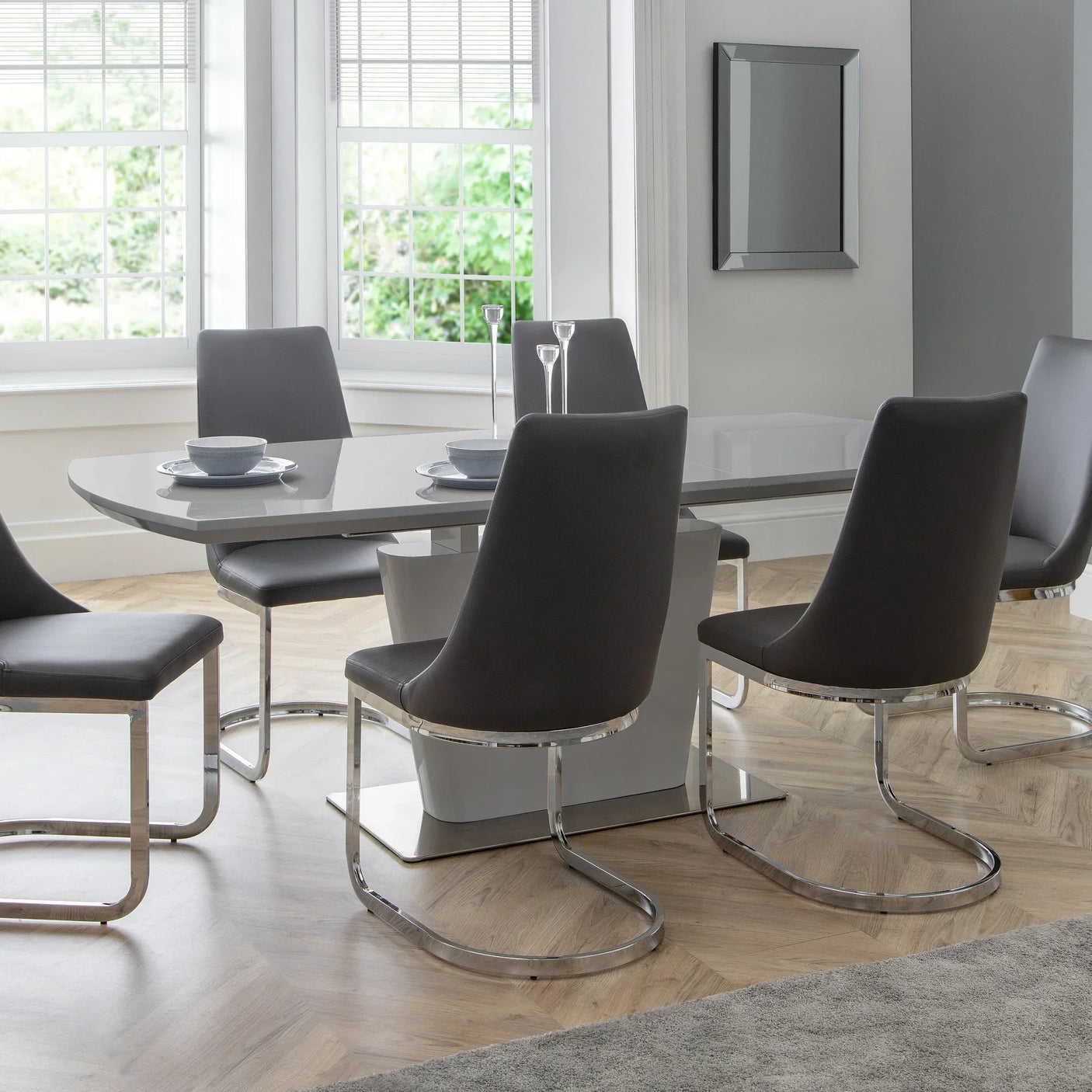 Grey dining table with six grey chairs and chrome legs in modern dining room setting