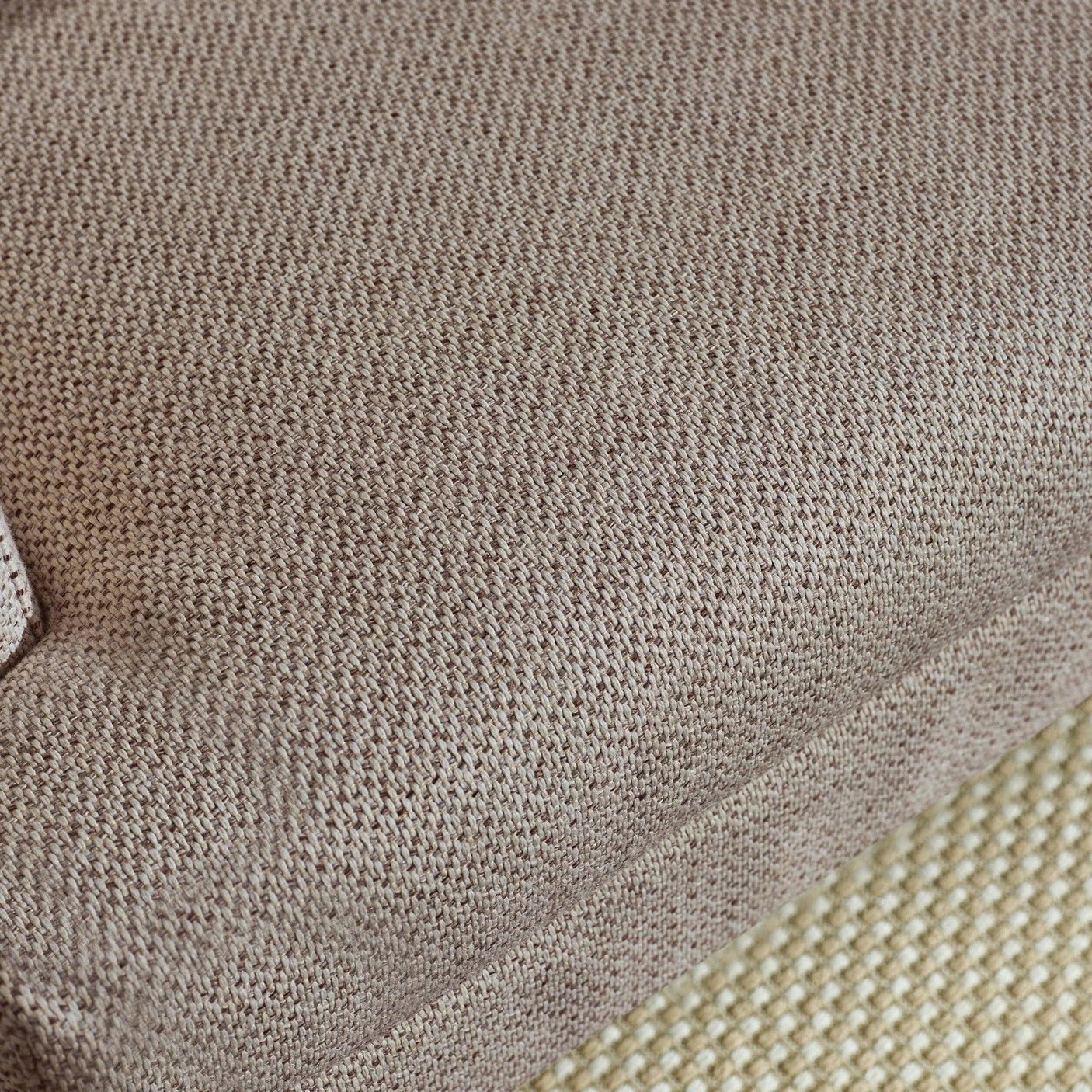 Close up of beige fabric sofa cushion with textured weave detail