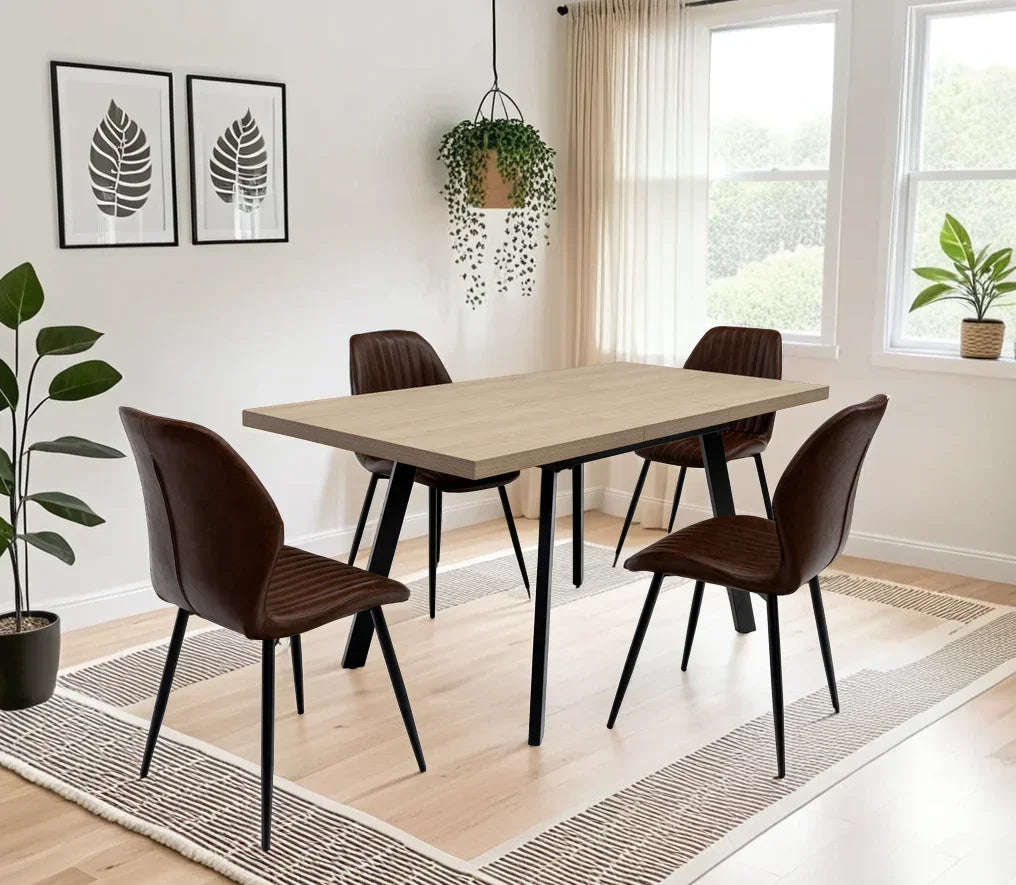 Modern dining table set with four brown chairs in bright dining room with plants