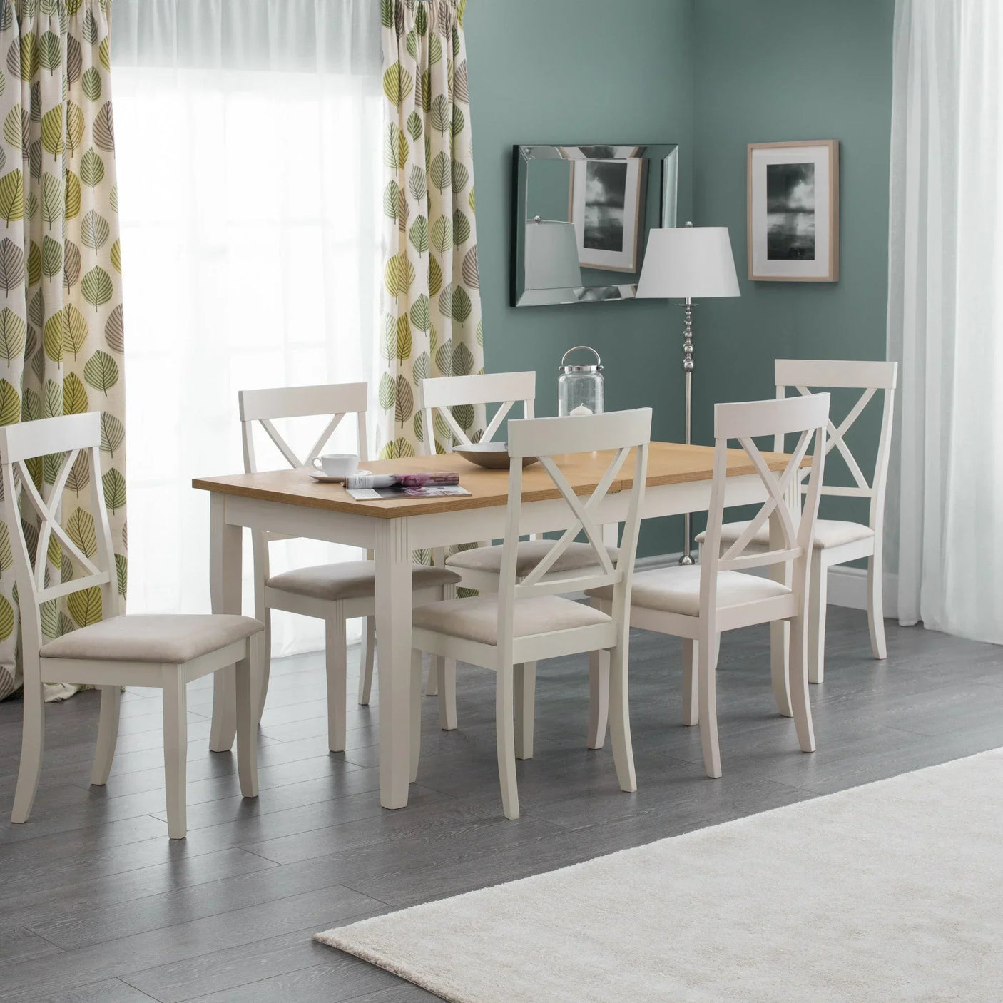 Modern dining table set with six white wooden chairs in bright room with green curtains