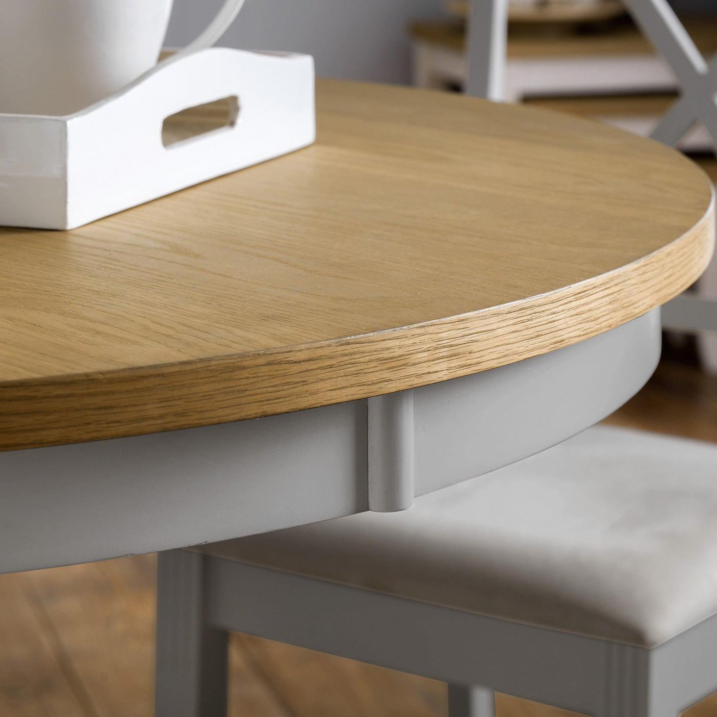 Round oak and grey pedestal table closeup showing wood grain and painted base detail